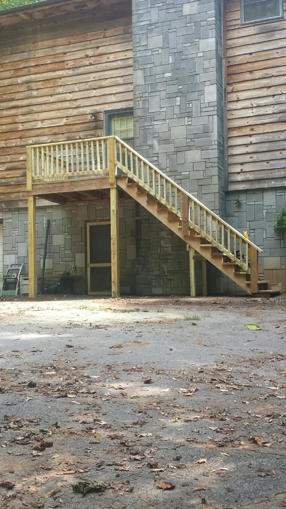 New pressure treated deck and stair landing on a log home in Elkin