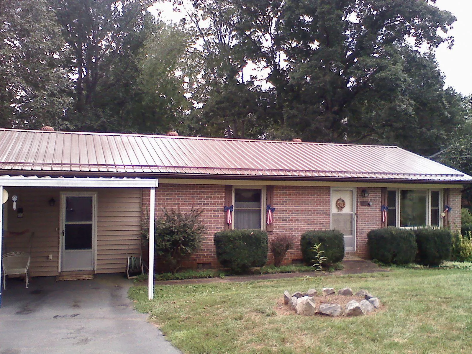 Bronze metal roof and carport on a brick ranch home — Roof Repair work by our crew in Elkin