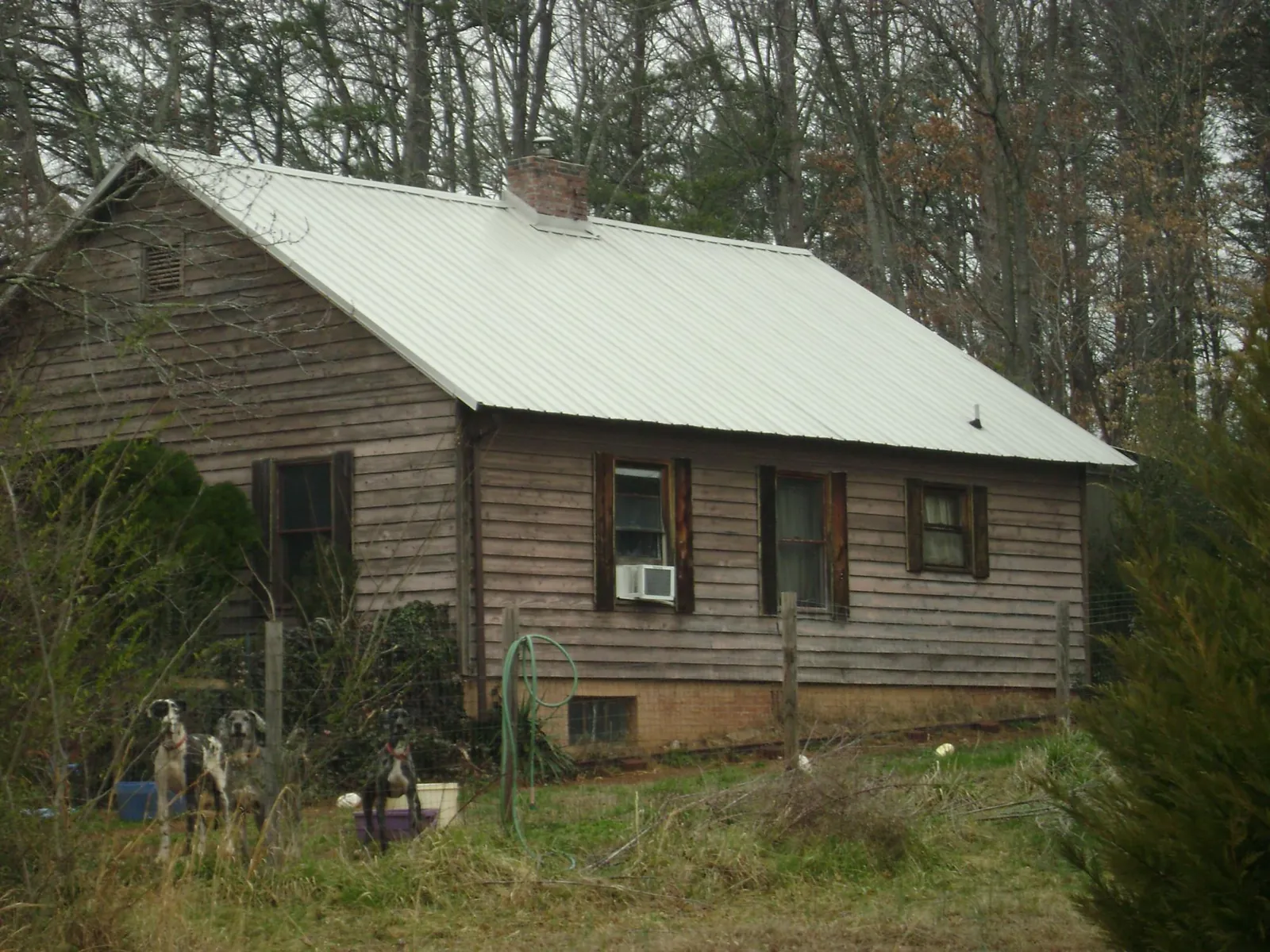 White metal roof on an old wood sided farmhouse, from a Metal Roof Installation job in Elkin
